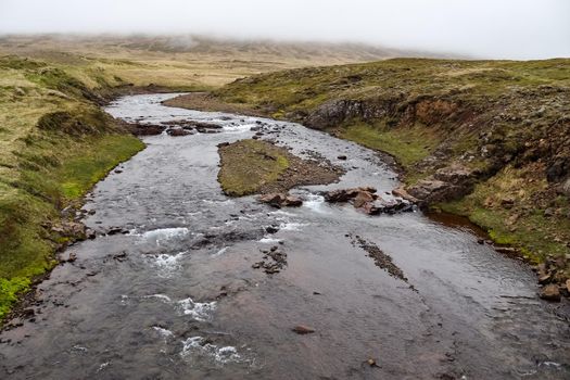 Fantastic landscape with flowing rivers and streams with rocks and grass in Iceland 