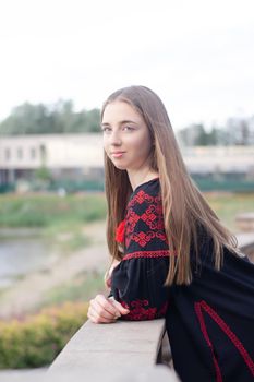 portrait of young woman wearing black and red vyshyvanka. national embroidered Ukrainian shirt. girl in dress outdoors in park. summer.