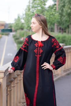 portrait of young woman wearing black and red vyshyvanka. national embroidered Ukrainian shirt. girl in dress outdoors in park. summer.