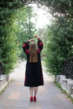 portrait of young woman wearing black and red vyshyvanka. national embroidered Ukrainian shirt. girl in dress outdoors in park. summer.