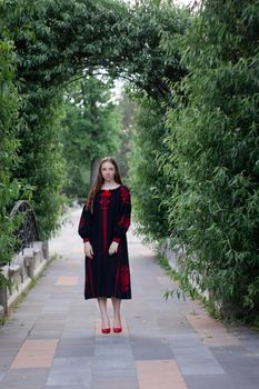 portrait of young woman wearing black and red vyshyvanka. national embroidered Ukrainian shirt. girl in dress outdoors in park. summer.