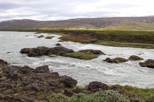 Fantastic landscape with flowing rivers and streams with rocks and grass in Iceland 