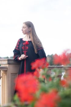 portrait of young woman wearing black and red vyshyvanka. national embroidered Ukrainian shirt. girl in dress outdoors in park. summer.