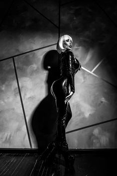 Sexy woman in a blonde wig and latex catsuit. Role-playing games.