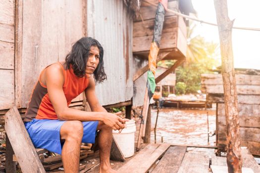 Long haired indigenous teenager sitting in a cabin on the coast of the pacific sea in Bluefields Nicaragua