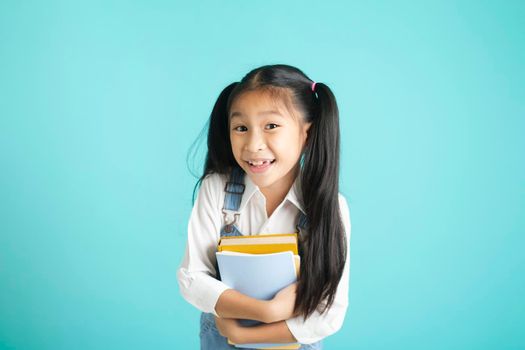 Close-up kid students girl smiling holding book, going to school. school concept.