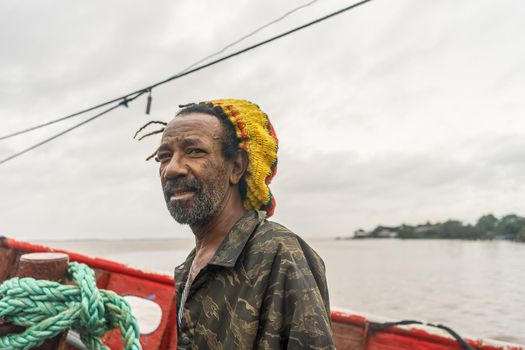 Black fisherman in the Caribbean of Nicaragua riding a boat and looking at the camera at the Bluefields pier