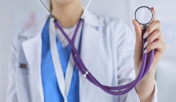 Smiling medical doctor woman with stethoscope in hospital.