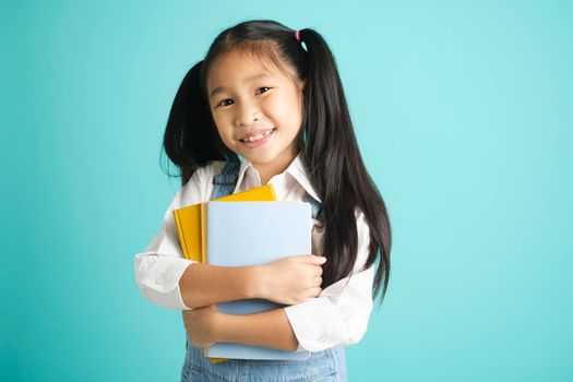 Close-up kid students girl smiling holding book, going to school. school concept.