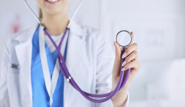 Smiling medical doctor woman with stethoscope in hospital.