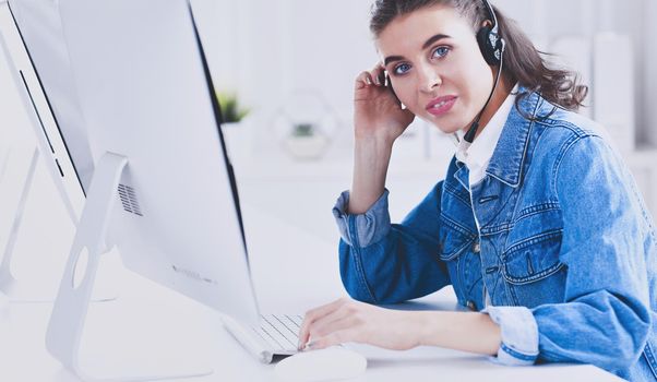Portrait of beautiful business woman working at her desk with headset and laptop