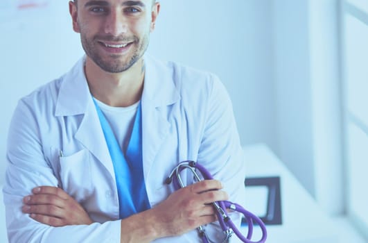 Young and confident male doctor portrait standing in medical office