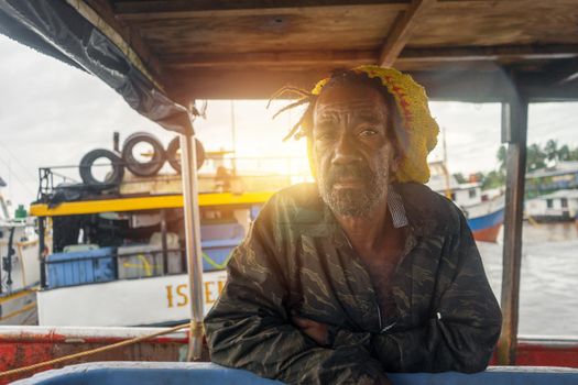 Black sailor with colorful cap at sunset on his fishing boat in Bluefields Nicaragua