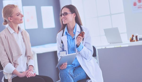 Doctor and patient discussing something while sitting at the table . Medicine and health care concept.