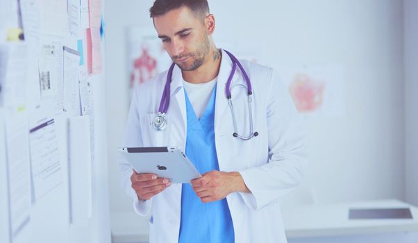 Young and confident male doctor portrait standing in medical office