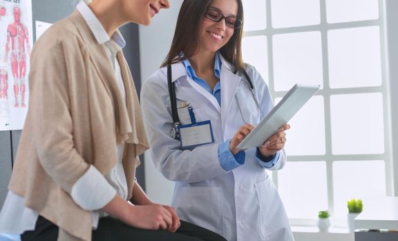 Doctor and patient discussing something while sitting at the table . Medicine and health care concept.