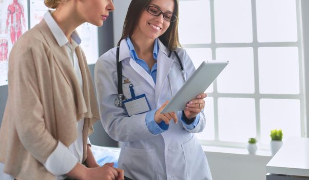 Doctor and patient discussing something while sitting at the table . Medicine and health care concept.