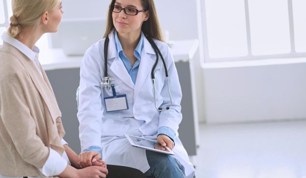Doctor and patient discussing something while sitting at the table . Medicine and health care concept.