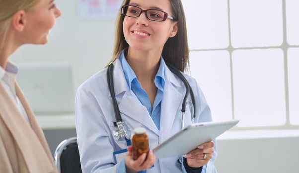 Doctor and patient discussing something while sitting at the table . Medicine and health care concept.