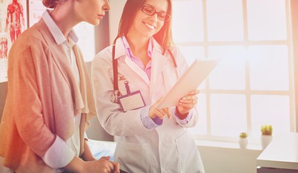 Doctor and patient discussing something while sitting at the table . Medicine and health care concept.