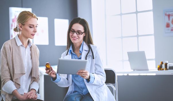 Doctor and patient discussing something while sitting at the table . Medicine and health care concept.
