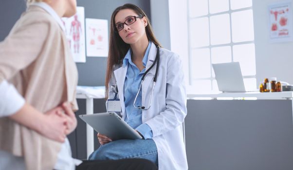 Doctor and patient discussing something while sitting at the table . Medicine and health care concept.