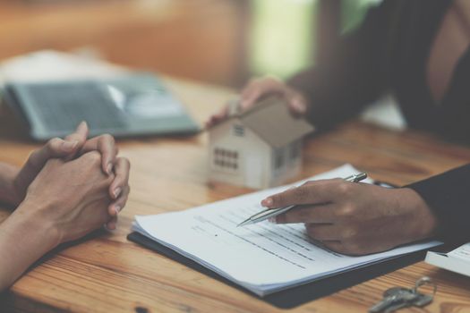 Close up Business woman or Real Estate agent giving house key after signing agreement for buying house. Bank manager and real estate concept