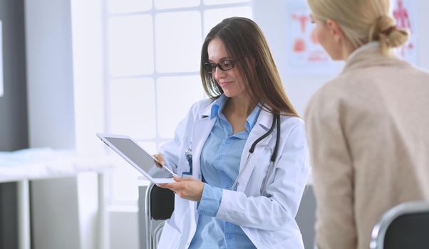 Doctor and patient discussing something while sitting at the table . Medicine and health care concept.