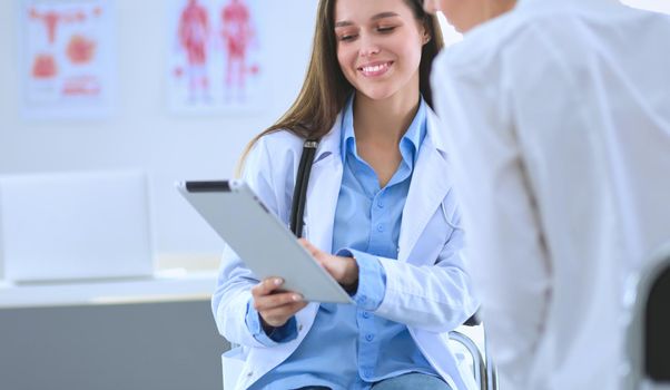Doctor and patient discussing something while sitting at the table . Medicine and health care concept.