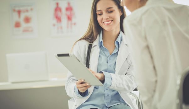 Doctor and patient discussing something while sitting at the table . Medicine and health care concept.