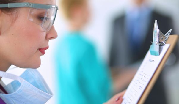 Woman doctor standing with folder at hospital .