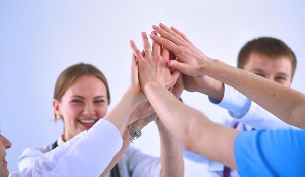 Doctors and nurses in a medical team stacking hands .