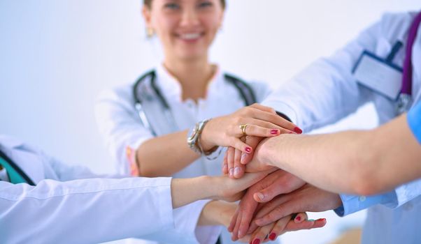 Doctors and nurses in a medical team stacking hands .