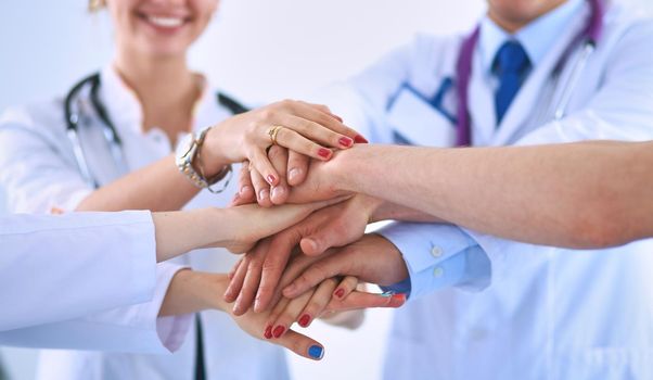 Doctors and nurses in a medical team stacking hands .