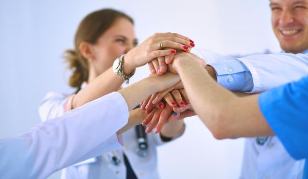 Doctors and nurses in a medical team stacking hands .