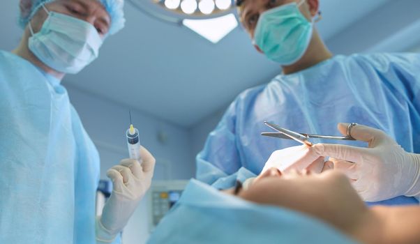 Team surgeon at work in operating room.