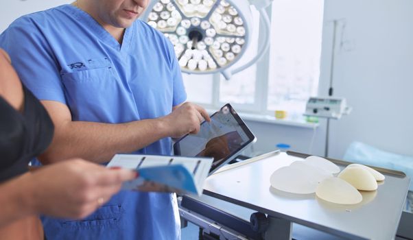 Doctor showing young patient her chest in his office at the hospital.