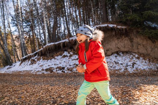 5 -7 y.o. joyful girl have a good time on autumn forest path.