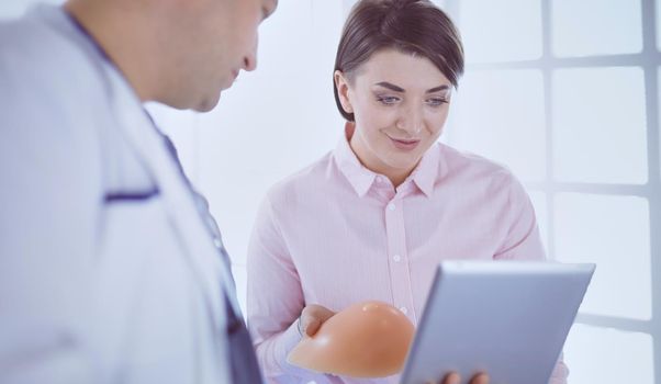 Doctor showing young patient her chest in his office at the hospital.