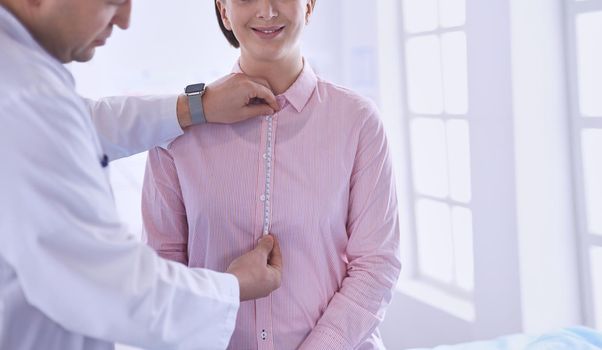 Doctor showing young patient her chest in his office at the hospital.