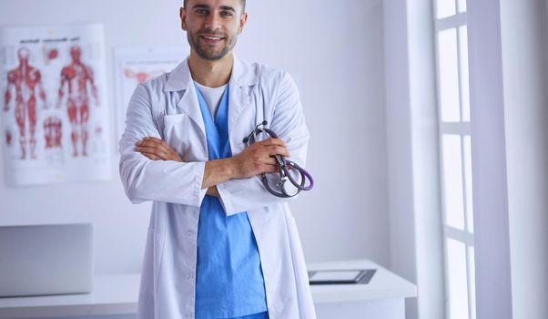 Young and confident male doctor portrait standing in medical office