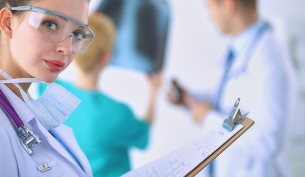 Woman doctor standing with folder at hospital .