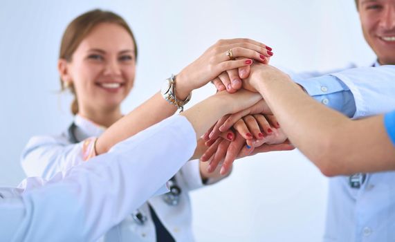Doctors and nurses in a medical team stacking hands .