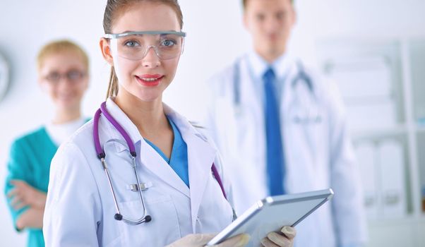 Woman doctor standing with folder at hospital .