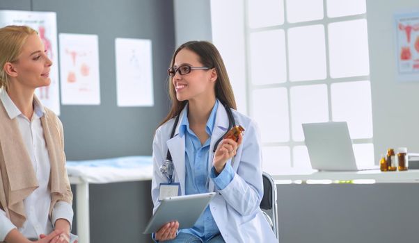 Doctor and patient discussing something while sitting at the table . Medicine and health care concept.