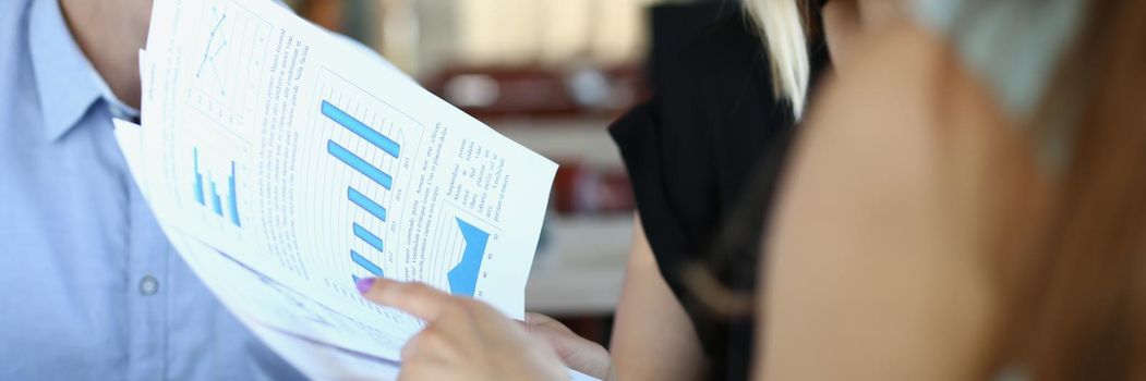 Close-up of business partners discuss report or contract in company office, businesspeople listen to employee. Business, career, strategy, deal concept