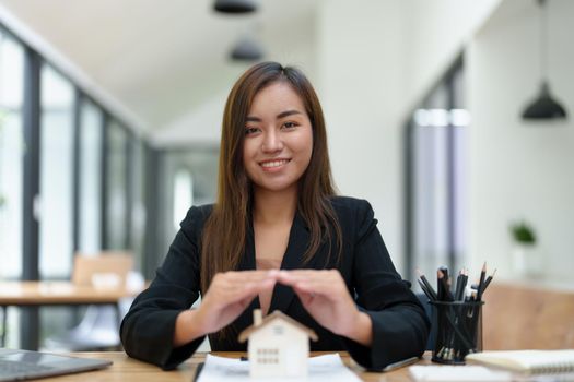 portrait of an asian woman, Agent, buy and sell land, property tax, show the concept of protecting the house to insure the risk of damage to the home.