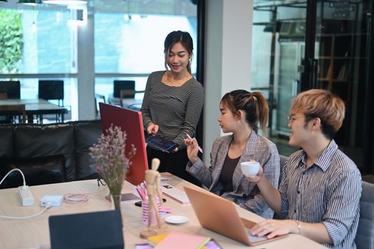 Team of coders brainstorming ideas for developing website design and coding technologies at modern office.