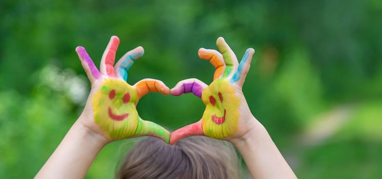 Children's hands in the colors of summer. Selective focus.arts