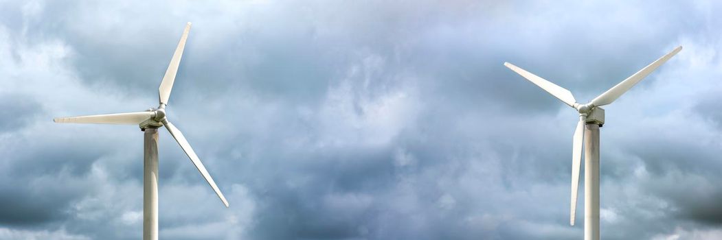 Windmills for electricity generation. Wind turbine against the background of a dark gloomy sky, windy weather, place to insert text